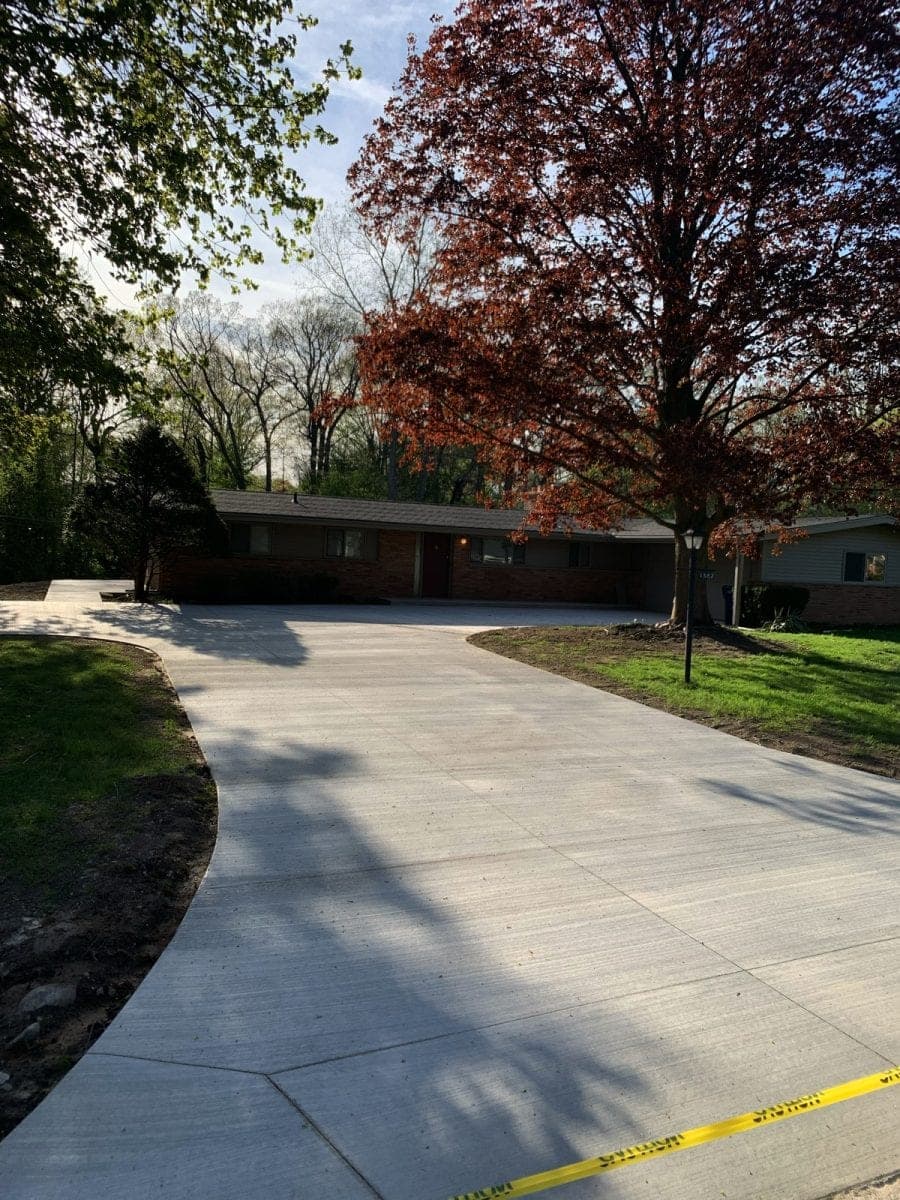 A concrete patio being sealed on a mild autumn day in Southwestern Ontario with sealer being applied by roller