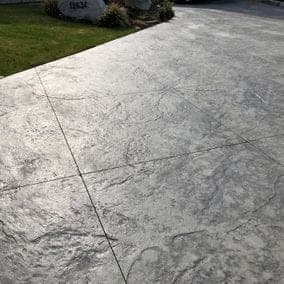 Close-up comparison of hazy white sealed concrete beside a clear, properly sealed section
