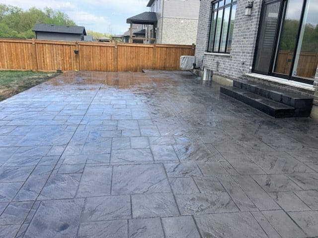 Vibrant sealed stamped concrete patio with enhanced colour and pattern definition in Brantford, Ontario